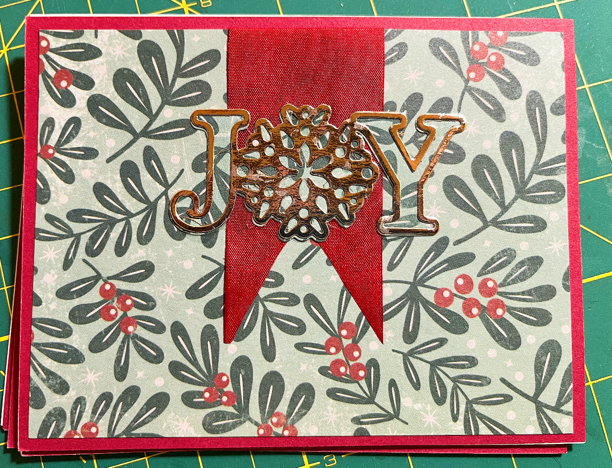 landscape orientation card, holly print paper, red ribbon, JOY in gold
