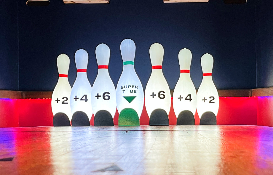 bowling pins on an indoor mini golf hole. each pin has a point value on it that you're awarded for hitting your ball in that pin's hole