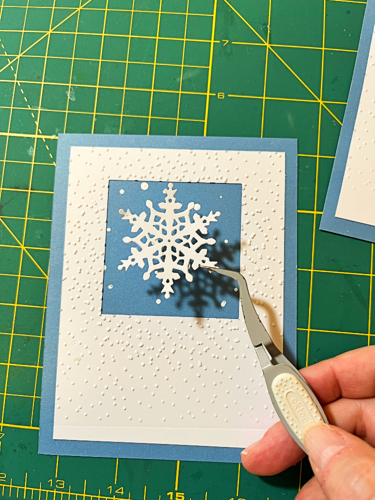 me using offset tweezers to place the snowflake on the card front