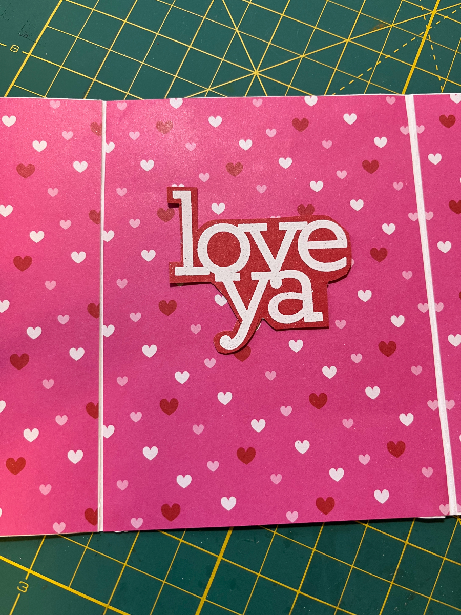 LOVE YA embossed in white on red cardstock, glued to wildly busy heart print paper