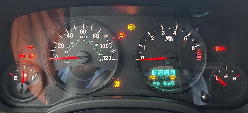a jeep dashboard with almost every light on and a "no bus" error message.
