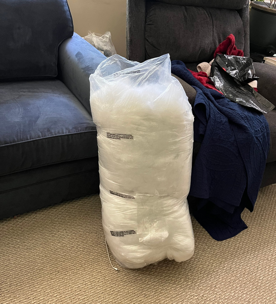 a large plastic bag of poly-fil, taller than the arms of my sofa.