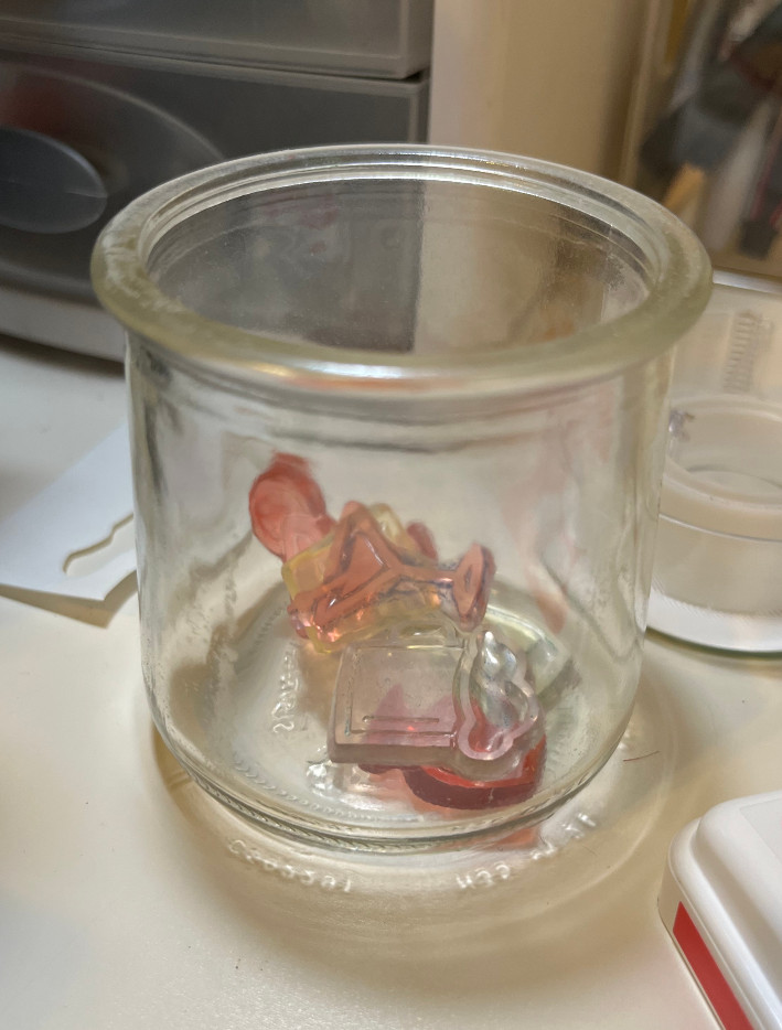 a small glass jar with inky stamps in it