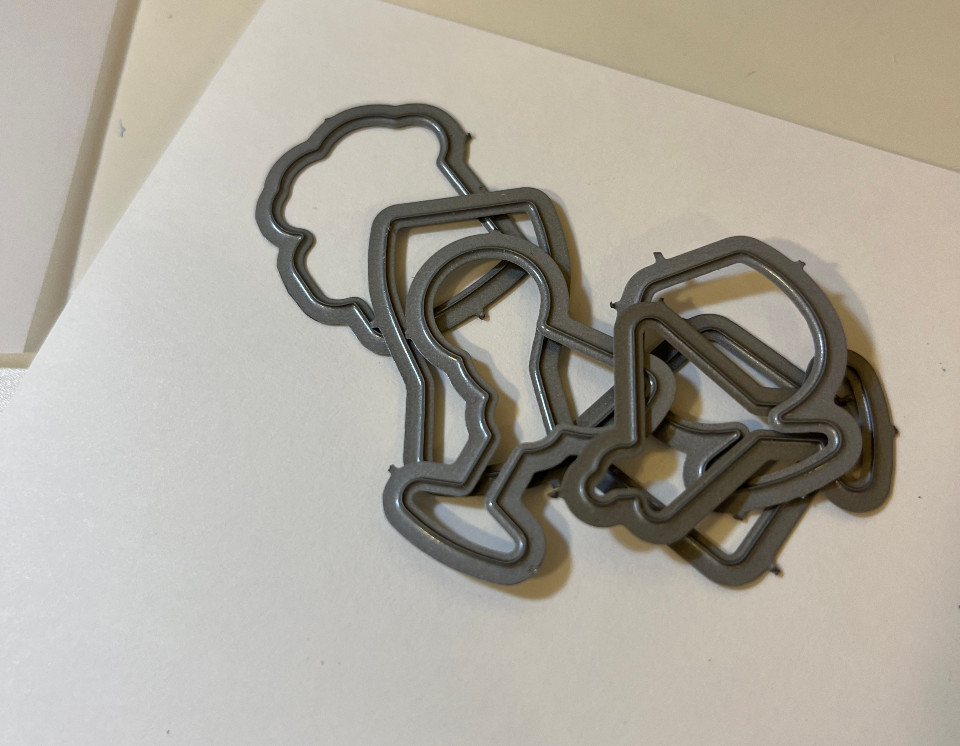 metal dies on top of a piece of cardstock.