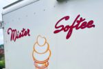 Kim holding a chocolate cone with chocolate jimmies in front of the Mister Softee truck