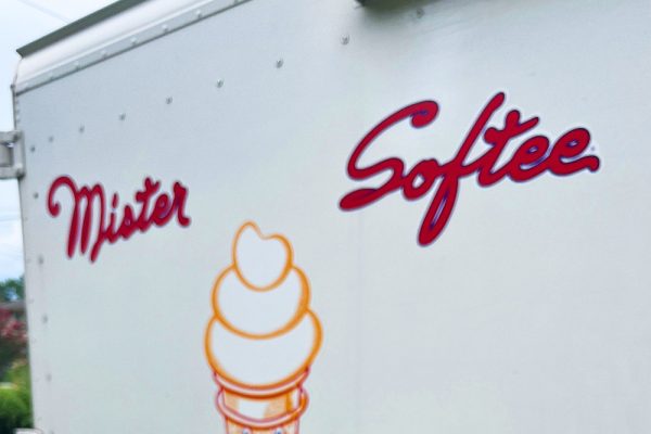 Kim holding a chocolate cone with chocolate jimmies in front of the Mister Softee truck